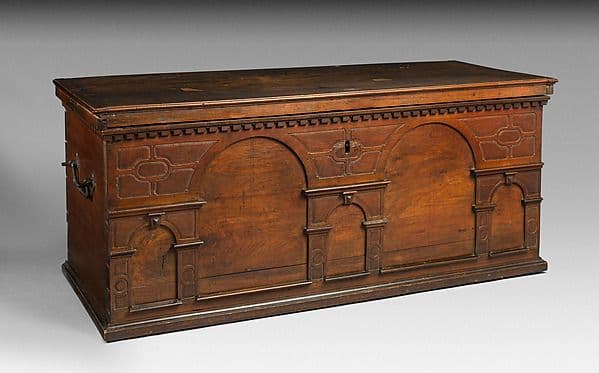 Walnut chest with a front of carved arches and moulded panels