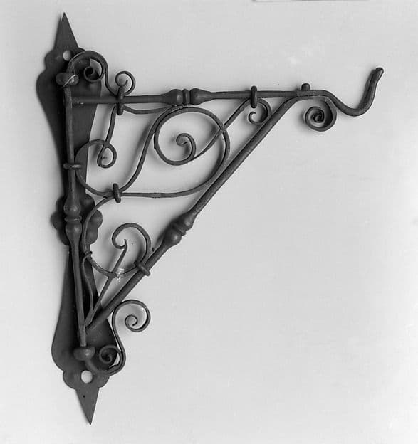Black wrought-iron wall bracket with decorative scrolls and a hook
