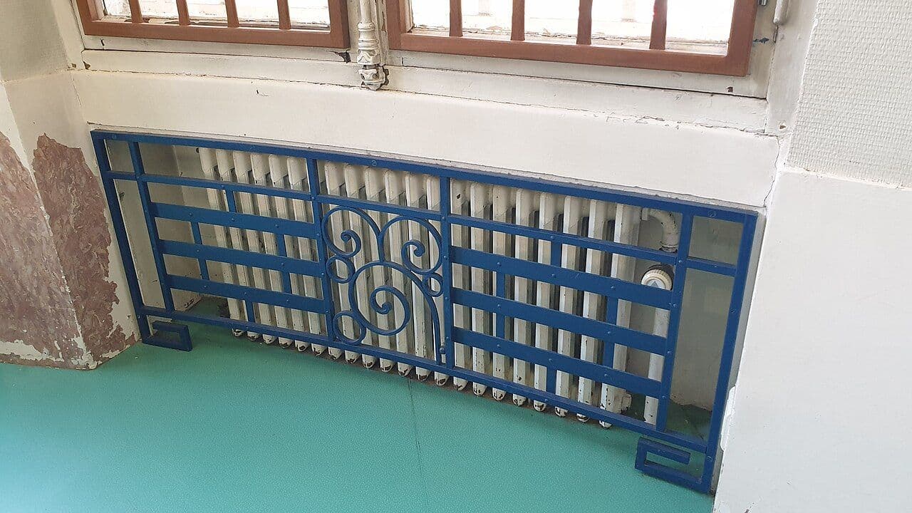 Geometric Art Deco metal grille covering a radiator