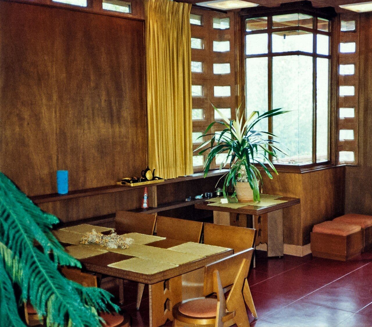 Mid-century dining area with pierced concrete block walls and built-in wood furniture