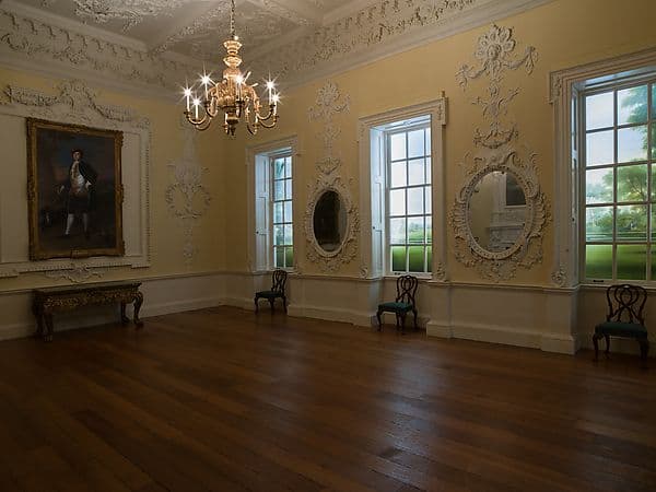 Georgian dining room with white and gold plasterwork wall panels, an ornate ceiling and a marble fireplace