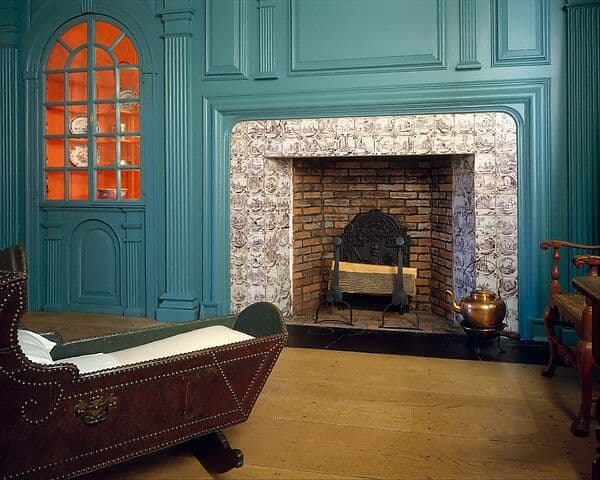 Colonial fireplace wall with raised panels, bolection-moulded surround and flanking cupboards