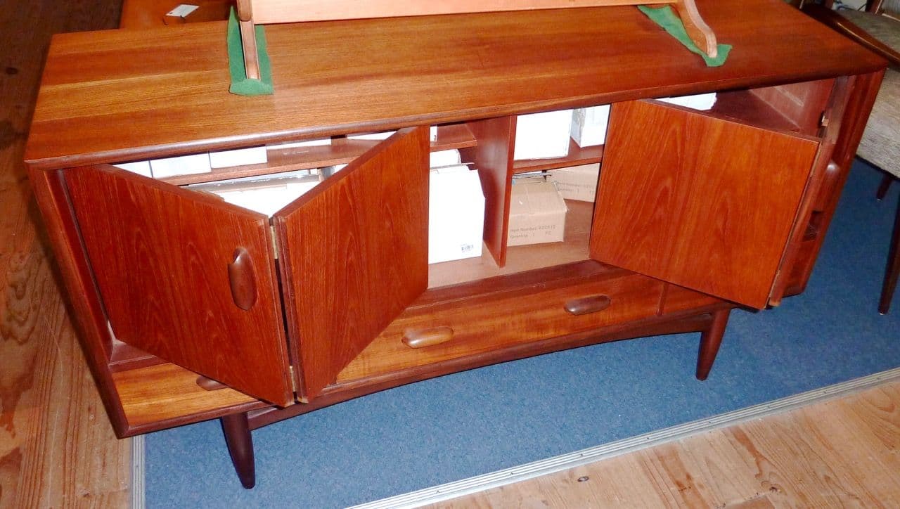 Teak mid-century sideboard with slab doors open to show shelves and drawers