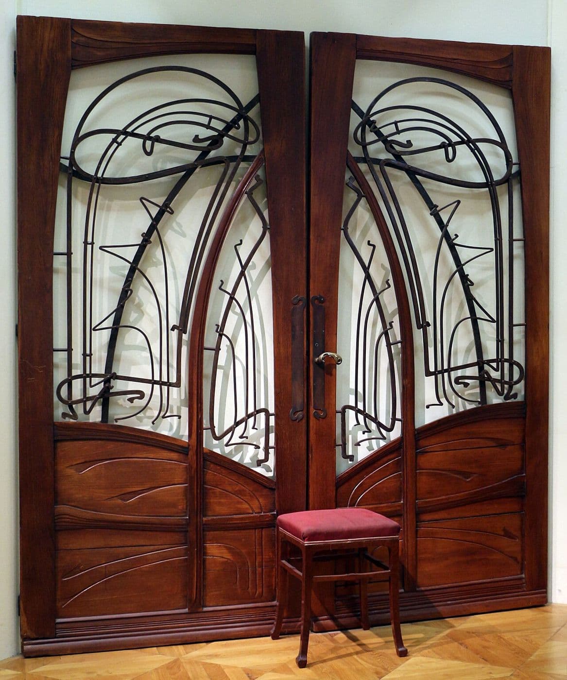 Carved wooden double door by Hector Guimard with flowing curves around glazed panels