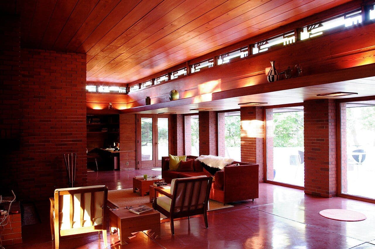 Usonian living room with a warm wood ceiling, clerestory windows and built-in furniture