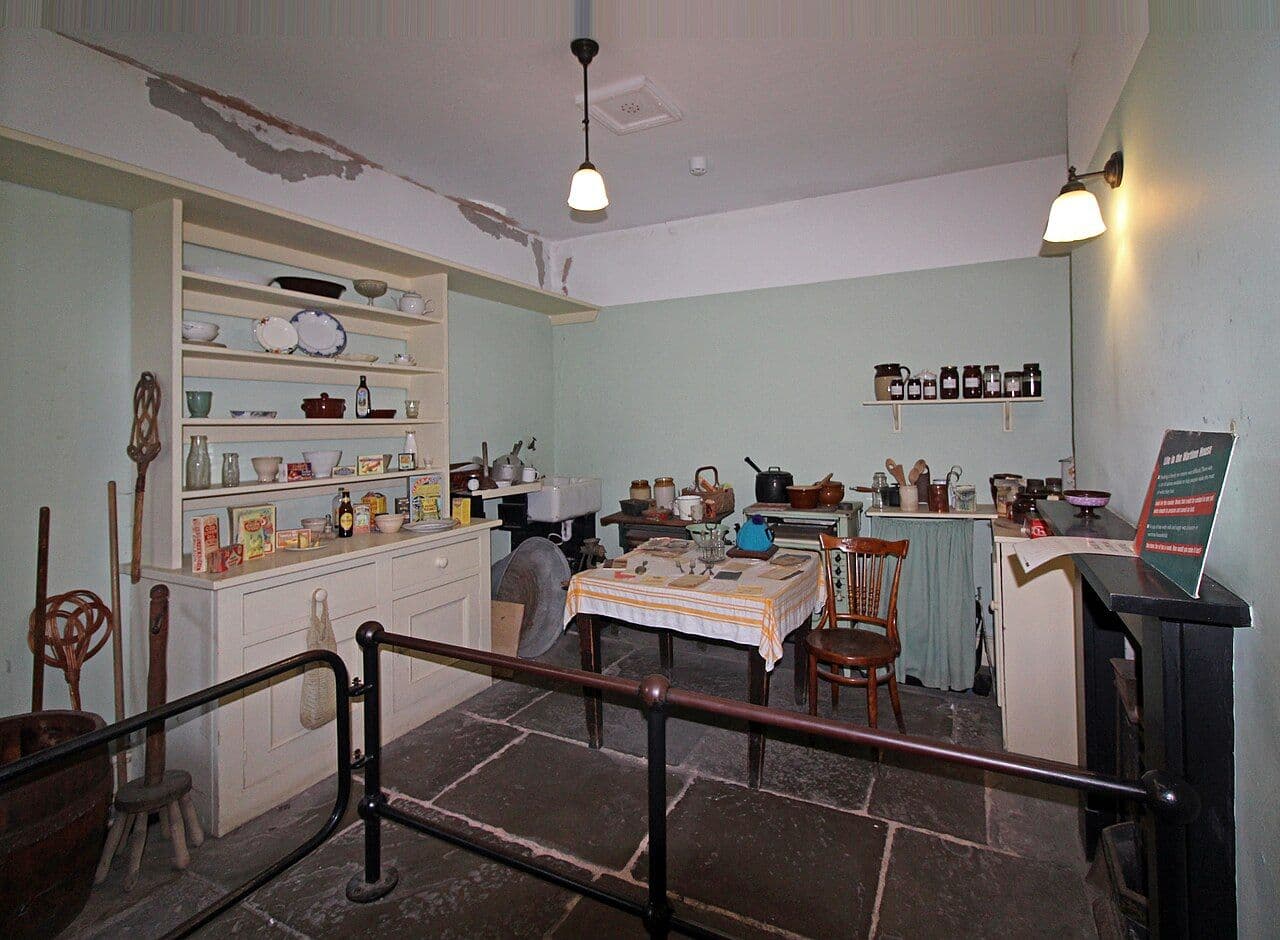 Modest kitchen with painted built-in shelving and cupboards and a small table