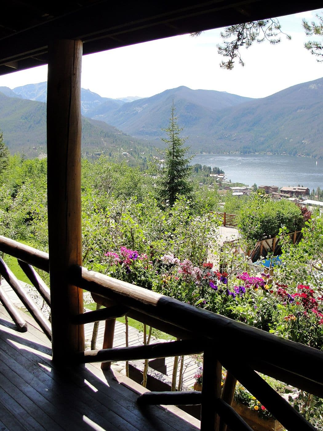 Log porch railing framing a view of a lake and mountains
