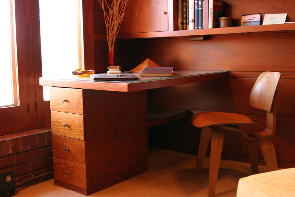 Mid-century built-in wooden desk with drawers and shelves and an Eames molded plywood chair