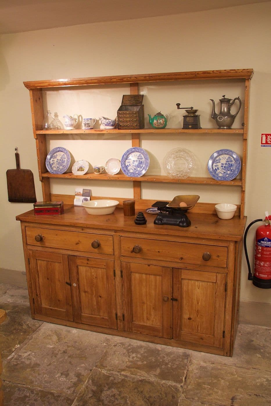 Pine kitchen dresser with open plate shelves above drawers and panelled cupboards
