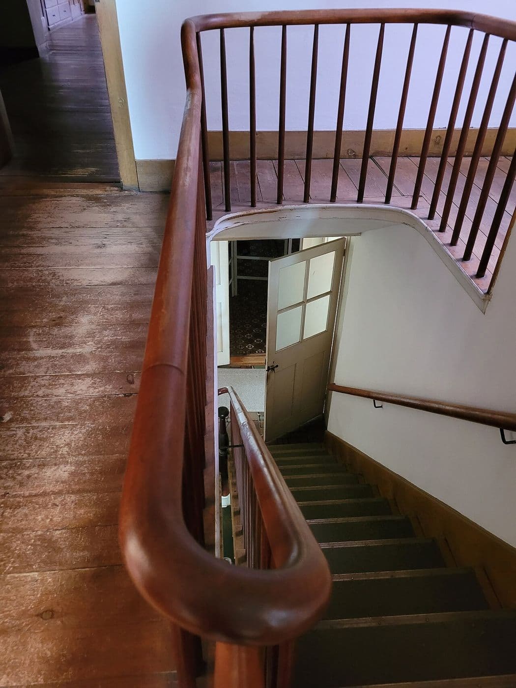 Shaker stairway with a slender wooden handrail and simple balusters